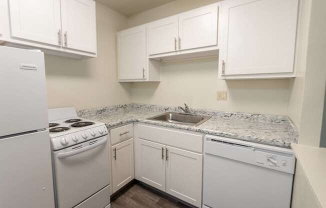 This is a photo of a kitchen with white cabinets and white appliances in a 560 square foot 1, 1 bath apartment at Park Lane Apartments in Cincinnati, OH.
