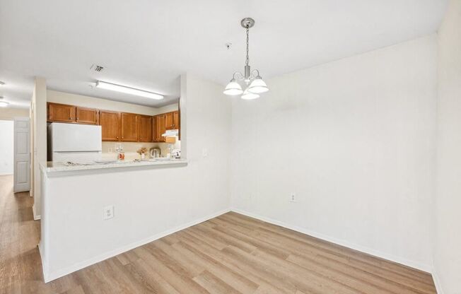 an empty living room and kitchen with wood flooring