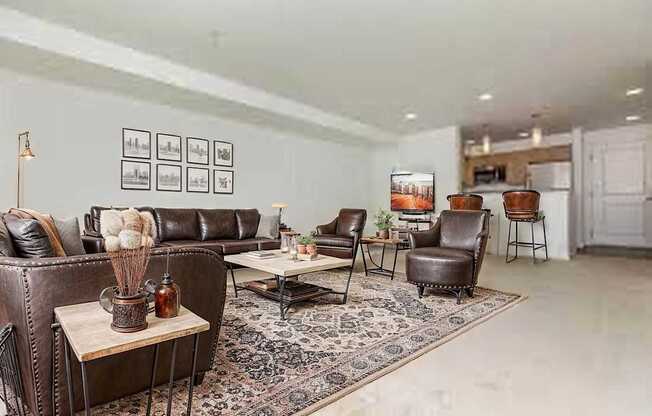 A living room with a brown leather couch and a rug.