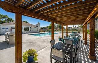 the private patio has a pergola and a pool with chairs and tables