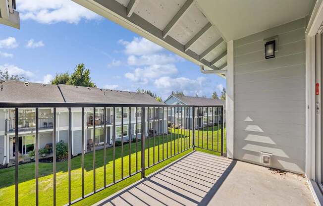 A balcony with a metal railing and a white wall.