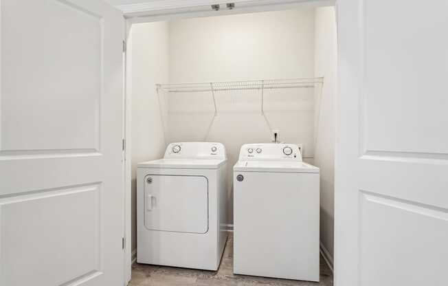 A white laundry room with a washer and dryer.