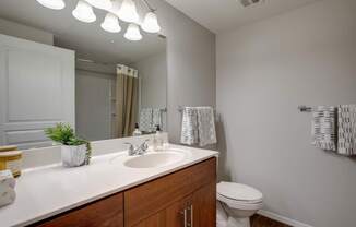 A bathroom with a white sink and a white toilet.