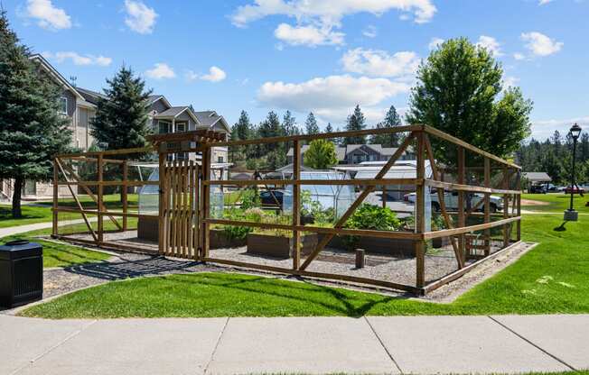 a garden area with a wooden structure and a pond in a park