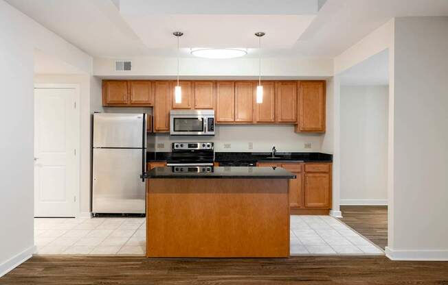 A kitchen with wooden cabinets and a black countertop.