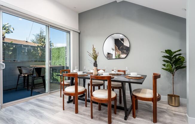 a dining room with a table and chairs and a mirror on the wall