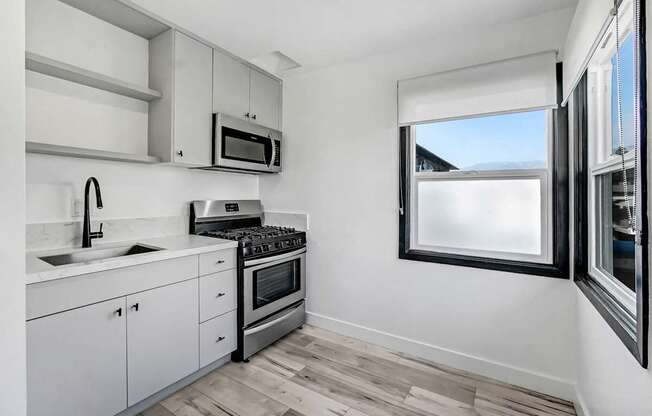 A kitchen with white cabinets and a window.