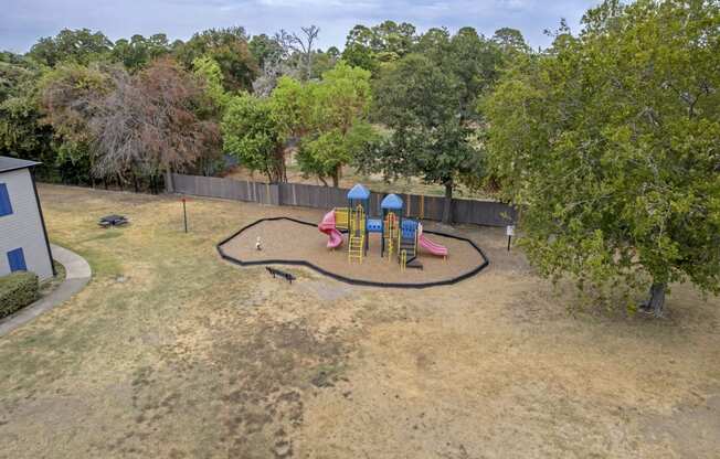 a playground is shown in a backyard with trees