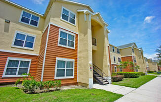 an apartment building with a sidewalk in front of it