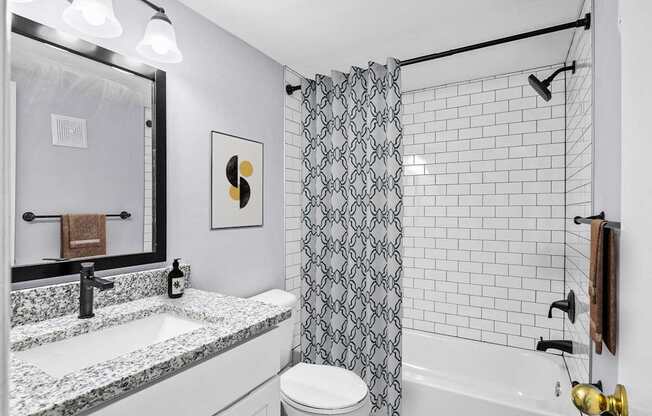 A bathroom with a black and white shower curtain.