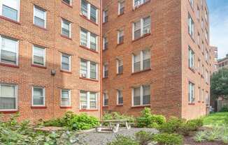 the courtyard of a brick building with a picnic table