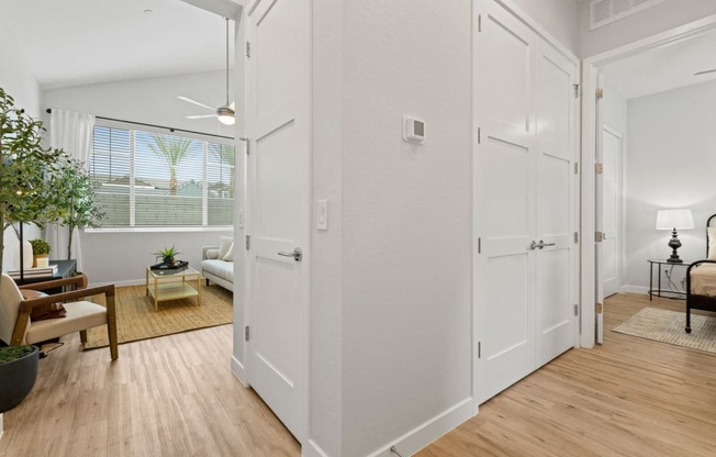 an open living room and dining room with white walls and wood floors at Village of Chandler Apartments, Arizona