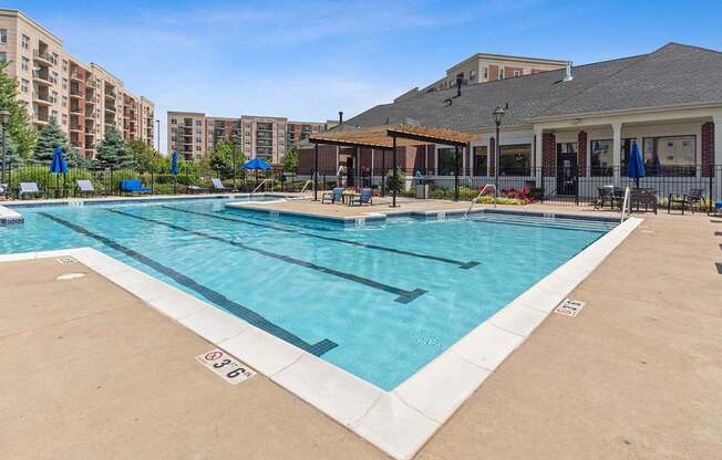 A large outdoor swimming pool with a building in the background.