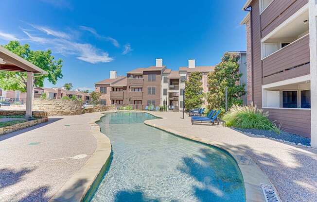 A swimming pool in a residential area surrounded by buildings and trees.