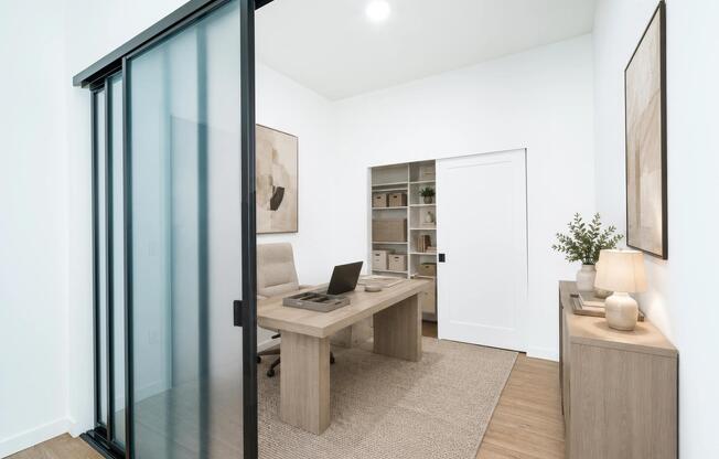 Flexible home office with a sliding glass partition, built-in shelving, and a clean layout that supports focus and everyday productivity.