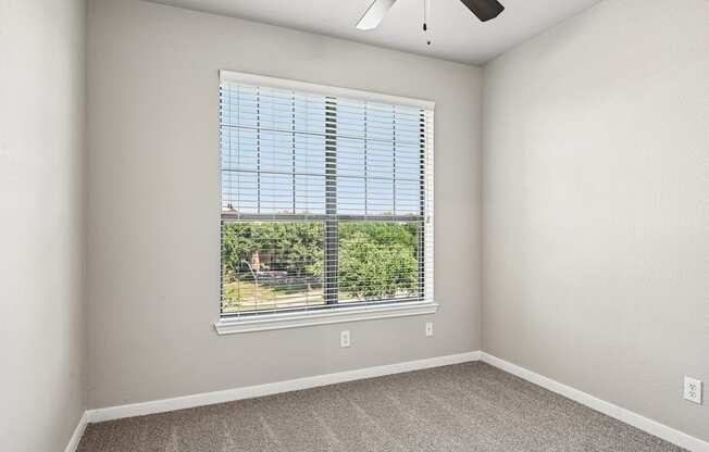 A room with a window and a ceiling fan.