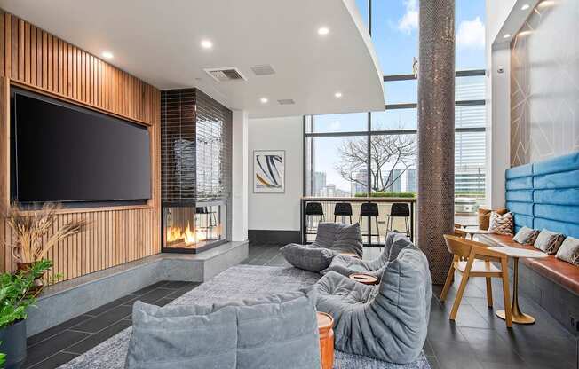 A modern living room with a grey sofa and a flat screen TV mounted on a wooden wall.