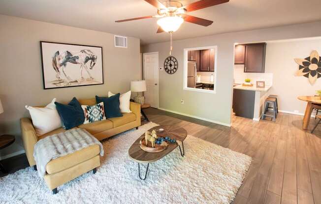 A living room with a couch, coffee table, and a ceiling fan.