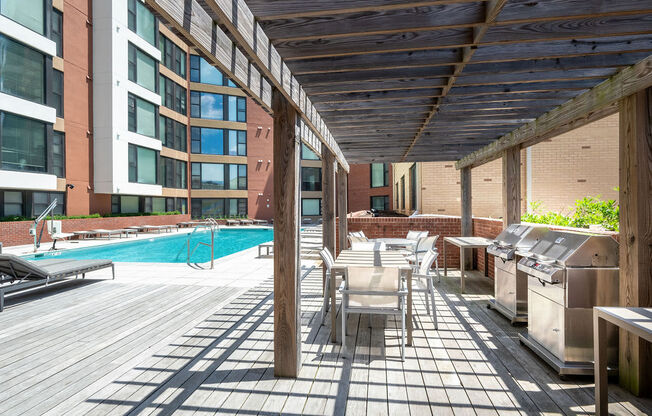 a patio with tables and chairs and a swimming pool