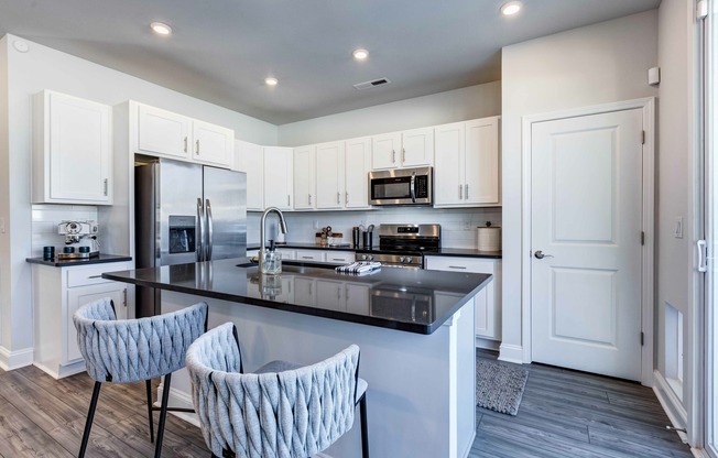 Gather and dine with Amavi Sherrills Ford's kitchens featuring a stylish kitchen island, offering room for bar seating.
