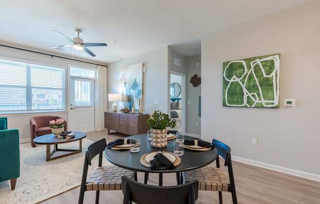 a living room with a round table and a ceiling fan