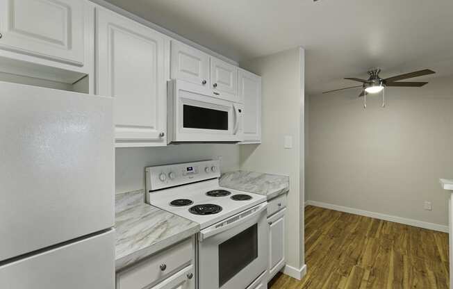 a kitchen with white cabinets and white appliances at Serra Vista Apartment Homes, Lynnwood, 98087