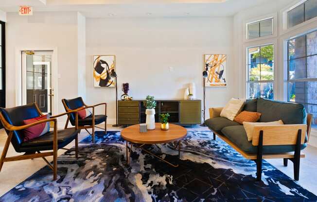 a living room with a couch and chairs and a rug