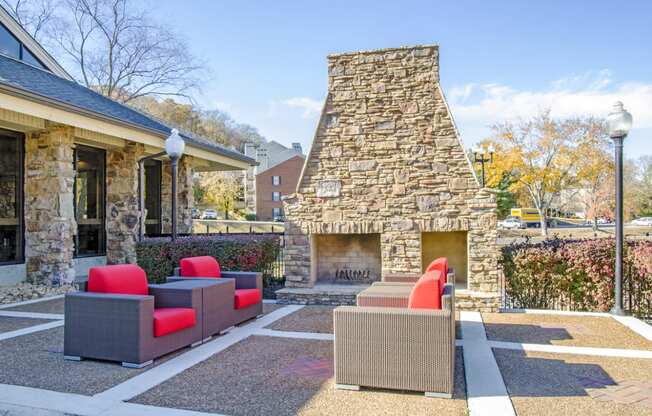 a patio with couches and a fireplace in front of a house