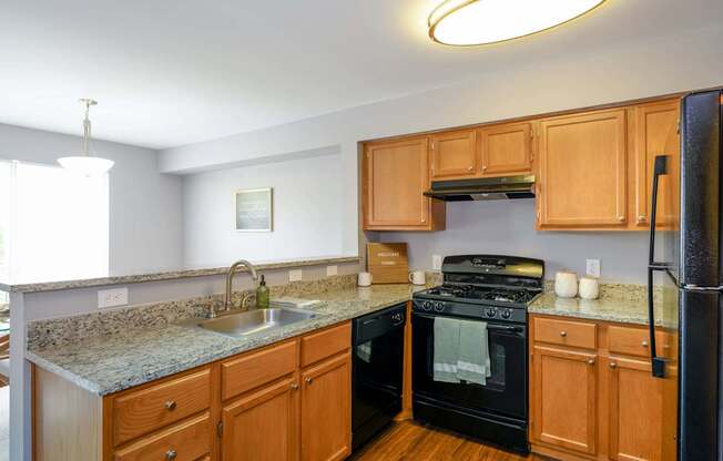 A kitchen with wooden cabinets and a black refrigerator.