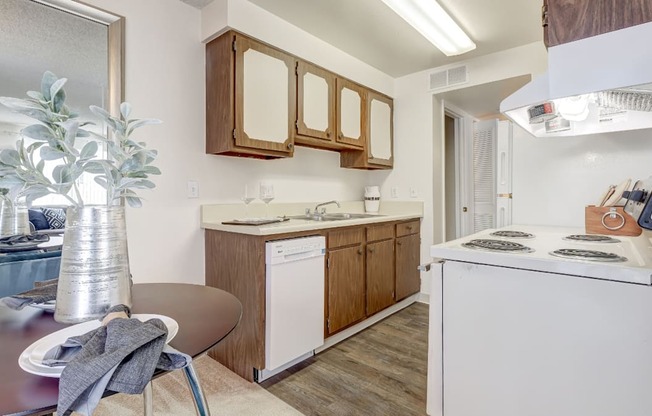 A kitchen with a white dishwasher and a white stove top oven.