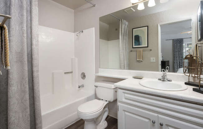 A white bathroom with a toilet, sink, and bathtub.