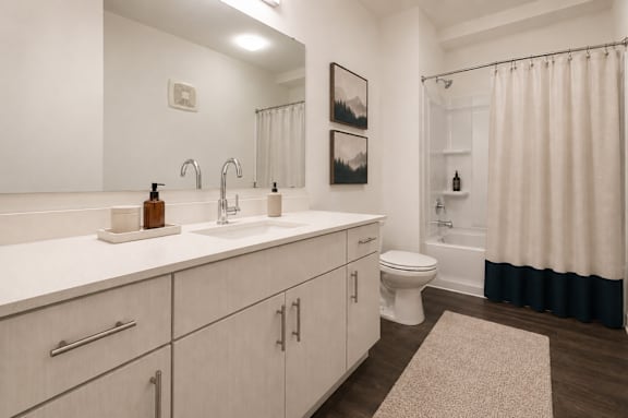 A bathroom with a white sink and a white toilet.