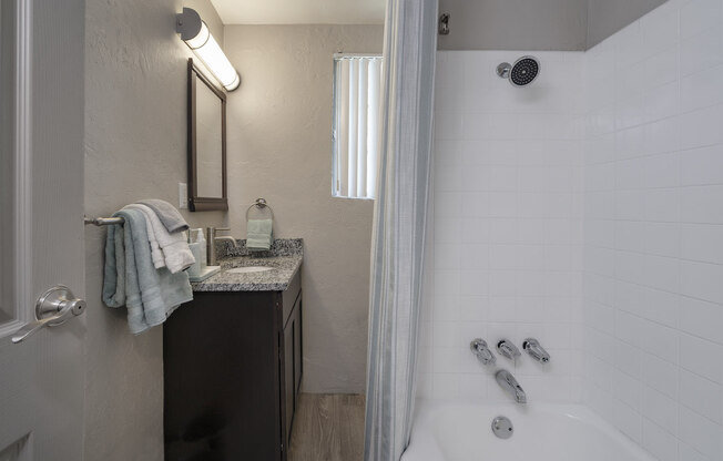 Bathroom with granite vanity countertop and over mirror lighting and shower/tub at Terraces at Clearwater Beach, Clearwater