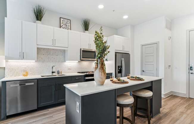 an open kitchen with a large island with two stools