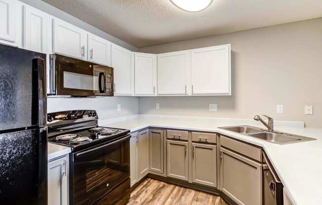a kitchen with white cabinets and black appliances