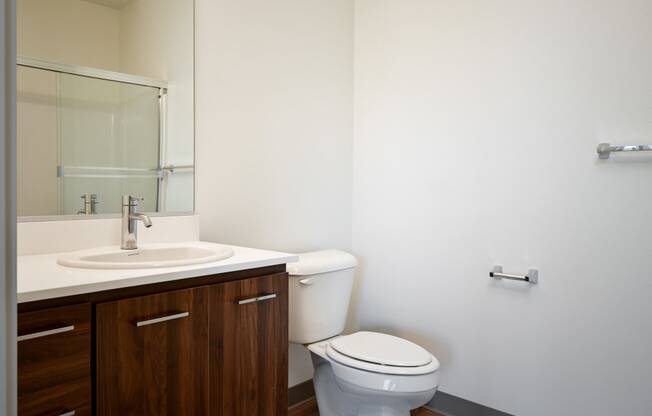 an empty bathroom with a toilet sink and mirror