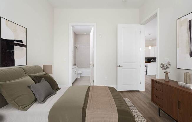 A bedroom with a bed, nightstand, and a painting on the wall.