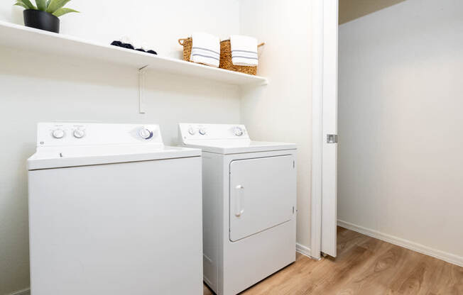 Two white washing machines in a laundry room.