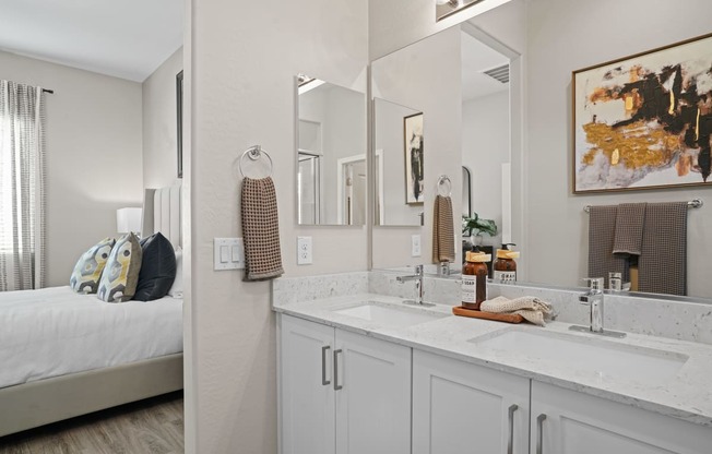 a bathroom with a sink and a mirror and a bedroom with a bed