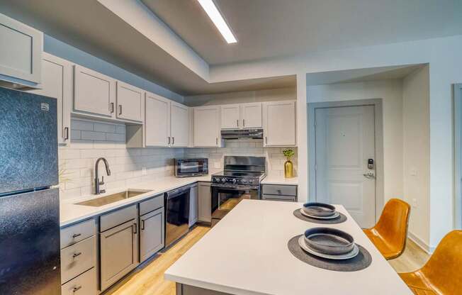 A modern kitchen with a white countertop and a sink.