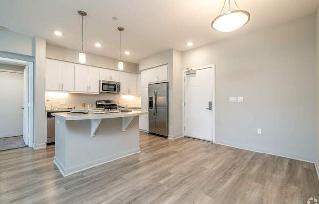 A kitchen with a white island and wooden floors.