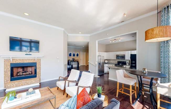 a living room with a fireplace and a kitchen with a table and chairs