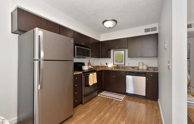 a kitchen with dark wood cabinets and stainless steel appliances