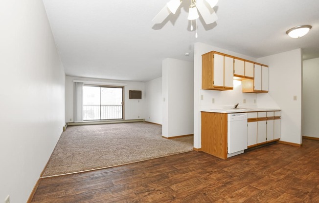 an empty living room and kitchen with wood flooring and a window .Anoka, MN Dellwood Estates