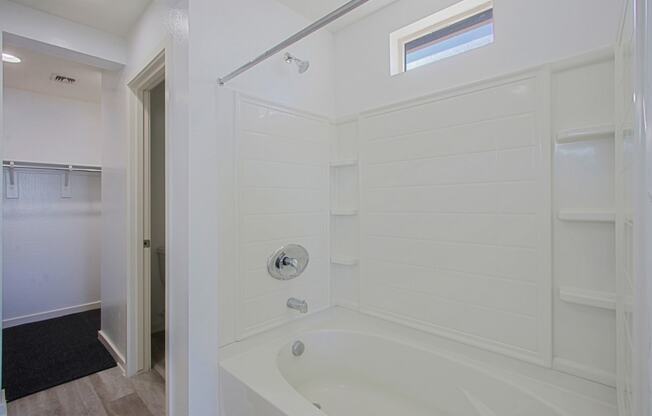 a white bathroom with a tub and a shower