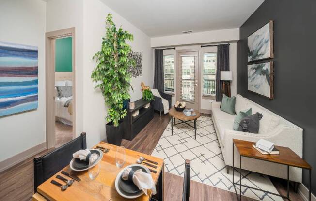 A dining table with chairs and a potted plant in a living room.
