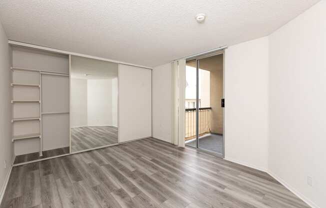 Bedroom with Hardwood Floors and Mirrored Wardrobe Closet