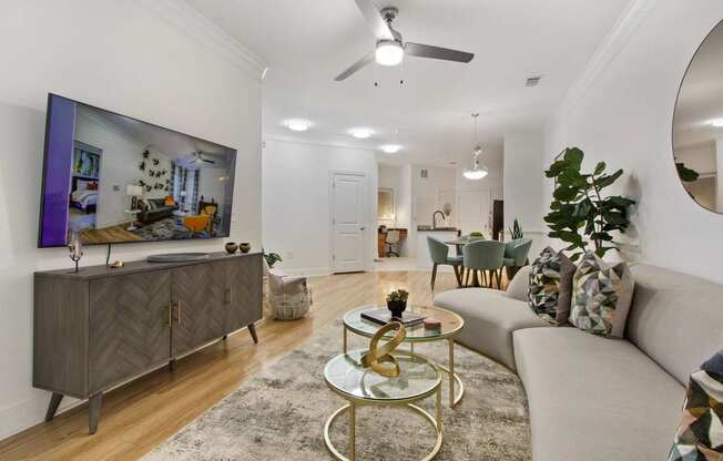 Apartments Near Washington D.C. - Tribeca at Camp Springs - A living room with a grey sofa, a coffee table, and a large