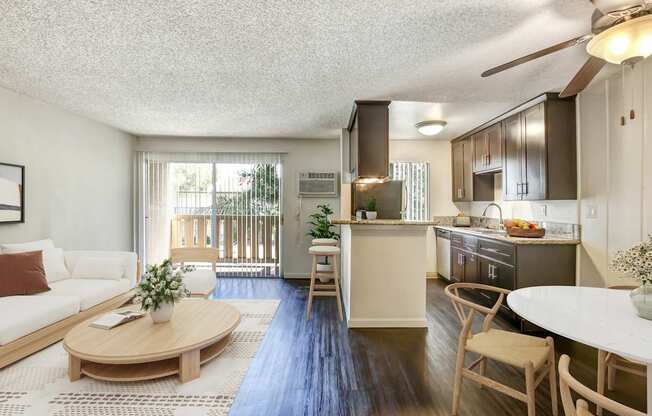 A well-lit, spacious kitchen and living room with a dining table and chairs.