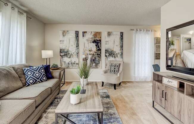 A living room with a couch, a coffee table, and a mirror.